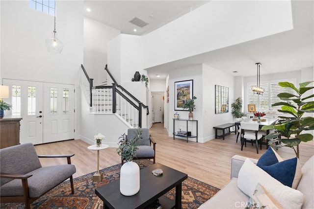 27811 Bloomfield Ct, Valencia, CA 91354 - living room with stairs, healthy amount of natural light, light wood-type flooring, a towering ceiling, and a chandelier