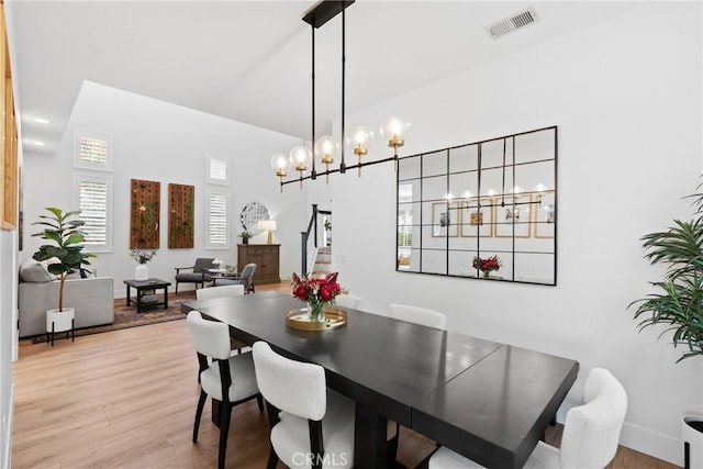 27811 Bloomfield Ct, Valencia, CA 91354 - dining space featuring light wood-style floors, a chandelier, stairs, and a high ceiling