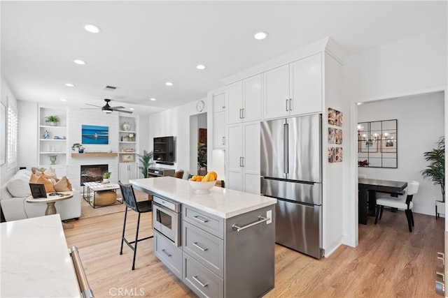 27811 Bloomfield Ct, Valencia, CA 91354 - kitchen featuring stainless steel fridge, gray cabinetry, recessed lighting, a ceiling fan, and a large fireplace