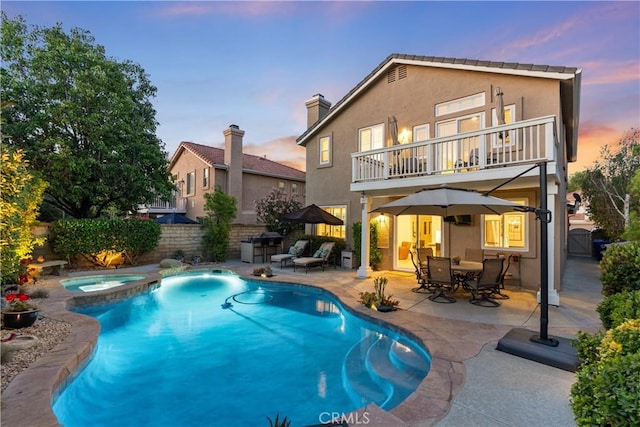 27811 Bloomfield Ct, Valencia, CA 91354 - back of house at dusk featuring a balcony, a patio, a fenced backyard, and stucco siding