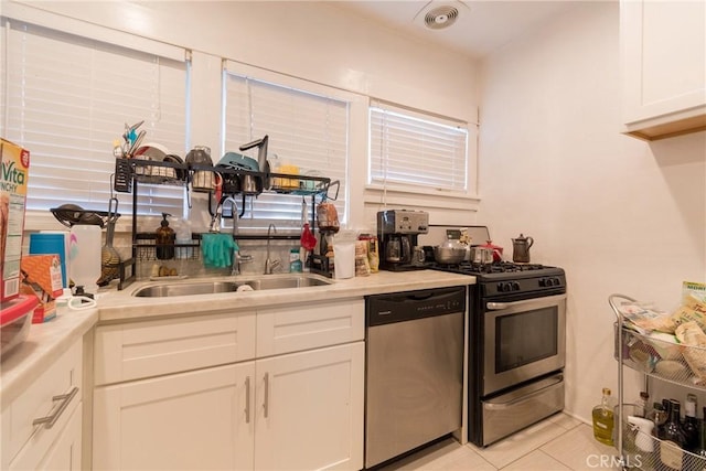 1517 E 1st St, Long Beach, CA 90802 - kitchen with stainless steel appliances, white cabinets, light countertops, and light tile patterned floors