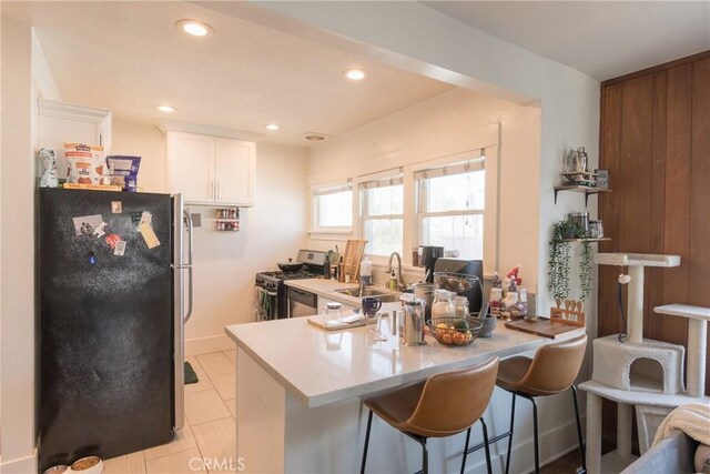 1517 E 1st St, Long Beach, CA 90802 - kitchen with appliances with stainless steel finishes, white cabinetry, a peninsula, a kitchen breakfast bar, and recessed lighting