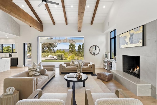 5508 Avenida Maravillas, Rancho Santa Fe, CA 92067 - living room with light wood-type flooring, a lit fireplace, ceiling fan, plenty of natural light, and high vaulted ceiling
