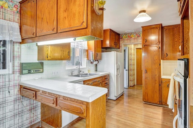 1106 Dawnridge Ave, El Cajon, CA 92021 - kitchen featuring white appliances, brown cabinets, light wood-style flooring, and tasteful backsplash