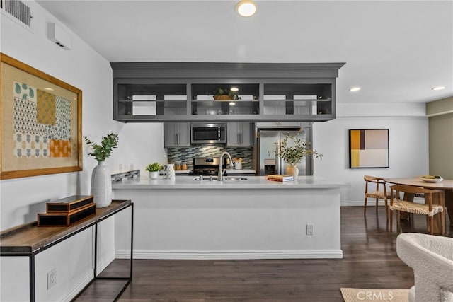 2700 Cahuenga Blvd E Unit 3104, Los Angeles, CA 90068 - kitchen featuring stainless steel appliances, a peninsula, dark wood-style flooring, recessed lighting, and backsplash