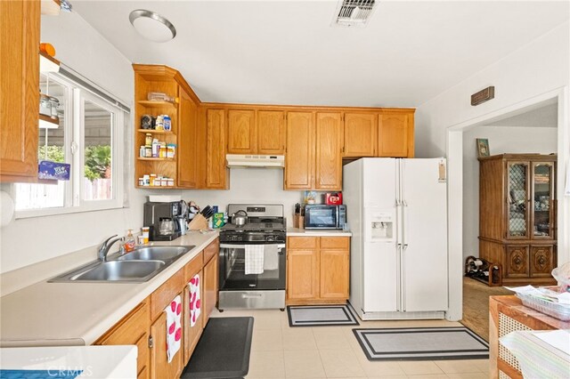 3551 Brynhurst Dr, Riverside, CA 92504 - kitchen featuring white fridge with ice dispenser, stainless steel gas range oven, light countertops, under cabinet range hood, and open shelves