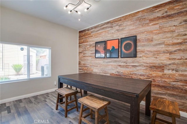 10105 S Main St, Los Angeles, CA 90003 - dining space with an accent wall, wood walls, wood finished floors, and a chandelier
