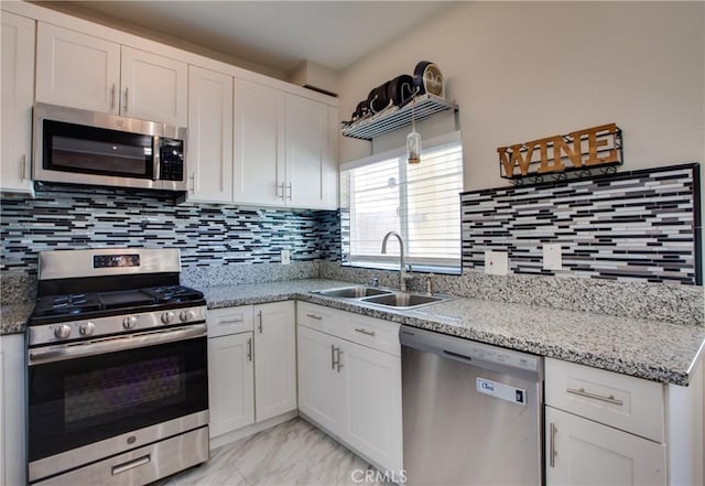 10105 S Main St, Los Angeles, CA 90003 - kitchen with appliances with stainless steel finishes, white cabinetry, light marble finish floors, tasteful backsplash, and light stone countertops
