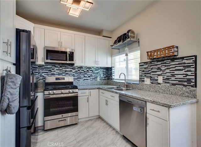 10105 S Main St, Los Angeles, CA 90003 - kitchen with stainless steel appliances, white cabinets, light marble finish floors, and tasteful backsplash