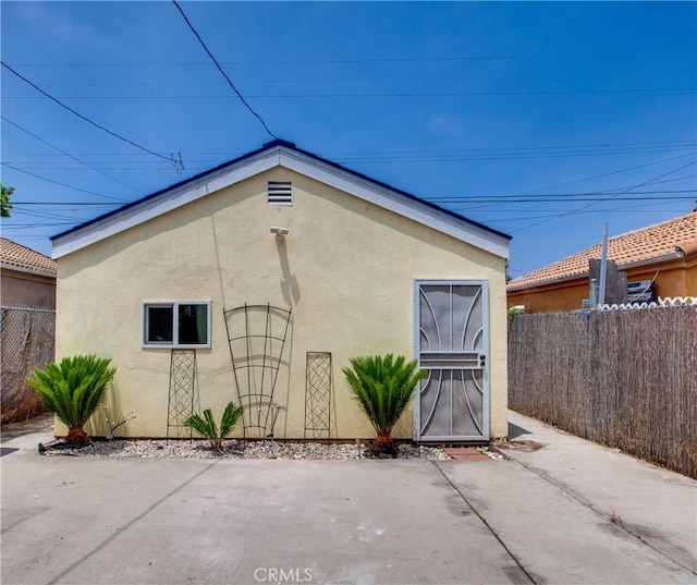 10105 S Main St, Los Angeles, CA 90003 - view of home's exterior with stucco siding and a patio area