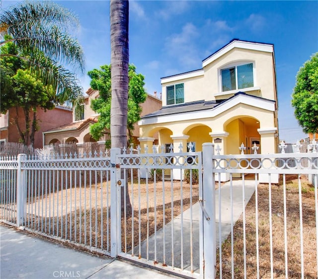 10105 S Main St, Los Angeles, CA 90003 - view of front of house featuring stucco siding, a fenced front yard, and covered porch