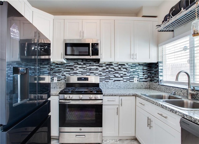 10105 S Main St, Los Angeles, CA 90003 - kitchen with appliances with stainless steel finishes, white cabinets, backsplash, and light stone countertops