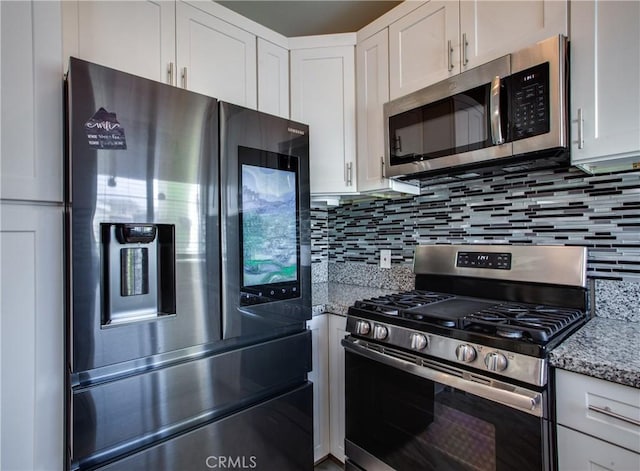 10105 S Main St, Los Angeles, CA 90003 - kitchen with stainless steel appliances, white cabinetry, decorative backsplash, and light stone countertops