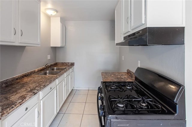 1270 W 9th St, Corona, CA 92882 - kitchen with black range with gas cooktop, under cabinet range hood, white cabinetry, dark stone counters, and light tile patterned flooring