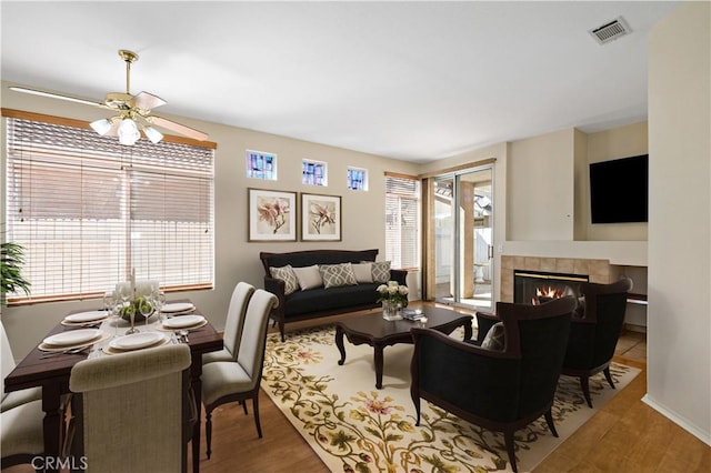 27812 Ruggie Rd, Menifee, CA 92585 - living room featuring a tile fireplace, wood finished floors, and ceiling fan