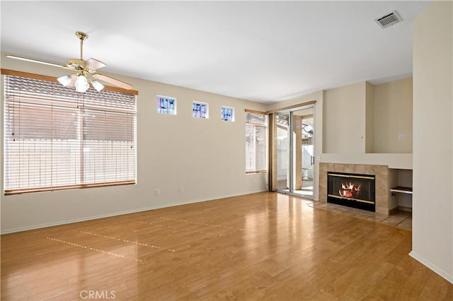 27812 Ruggie Rd, Menifee, CA 92585 - unfurnished living room featuring wood finished floors, ceiling fan, and a tiled fireplace