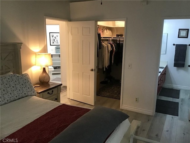 9144 Oakleaf Ct, Hesperia, CA 92344 - bedroom with light wood-style flooring, a walk in closet, and a closet