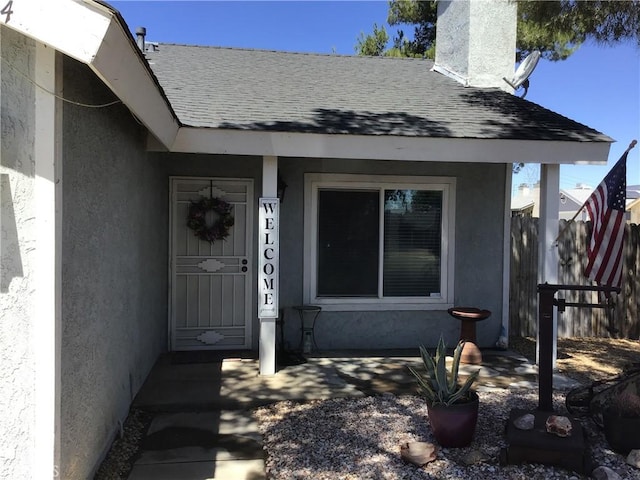 9144 Oakleaf Ct, Hesperia, CA 92344 - view of exterior entry featuring stucco siding, roof with shingles, and a chimney