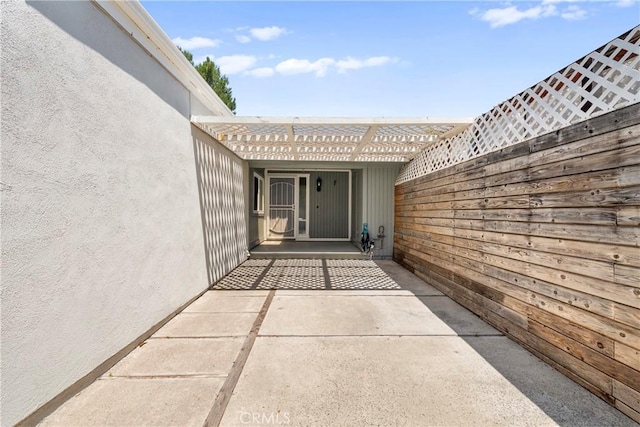 22271 Caminito Danubo, Laguna Hills, CA 92653 - view of exterior entry featuring stucco siding, a pergola, and a patio area