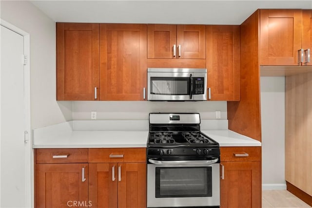 22271 Caminito Danubo, Laguna Hills, CA 92653 - kitchen featuring stainless steel appliances, brown cabinets, and light countertops
