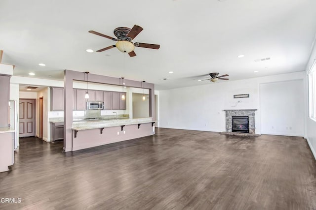 4069 Bristlecone Pine Ln, San Bernardino, CA 92407 - unfurnished living room with a ceiling fan, recessed lighting, dark wood-type flooring, and a stone fireplace