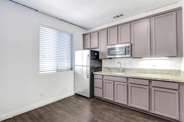 4069 Bristlecone Pine Ln, San Bernardino, CA 92407 - kitchen featuring stainless steel appliances, gray cabinets, dark wood finished floors, and light stone counters