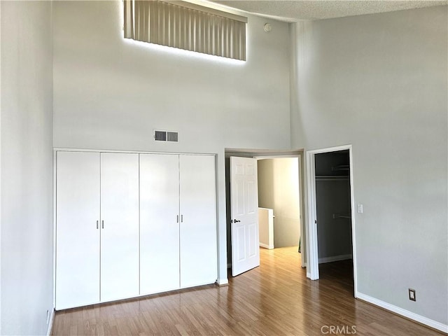 6801 Mammoth Ave Unit 6, Van Nuys, CA 91405 - unfurnished bedroom with a towering ceiling, a closet, and wood finished floors