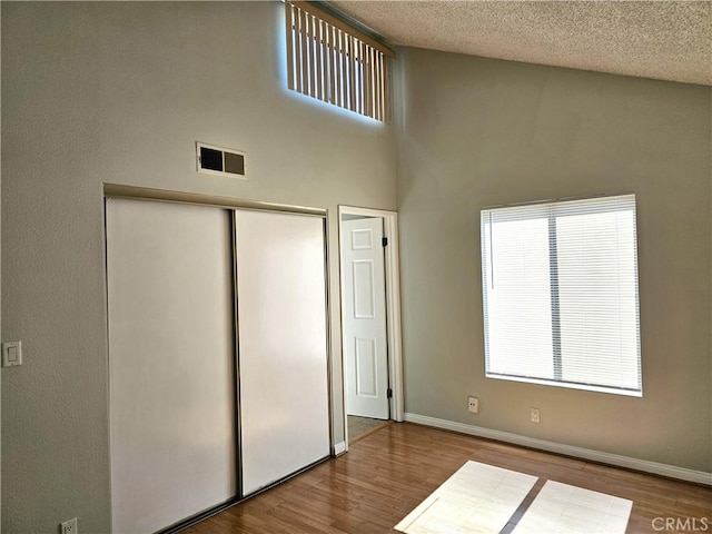 6801 Mammoth Ave Unit 6, Van Nuys, CA 91405 - unfurnished bedroom featuring wood finished floors, multiple windows, a closet, and a textured ceiling
