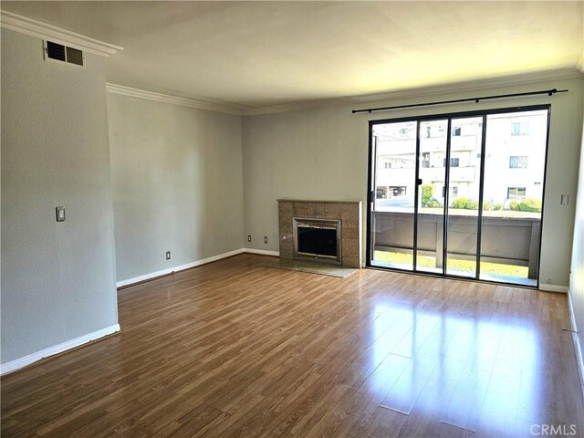 6801 Mammoth Ave Unit 6, Van Nuys, CA 91405 - unfurnished living room with ornamental molding, dark wood-type flooring, and a tile fireplace