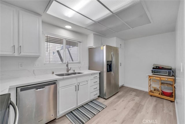 5510 Paseo Del Lago W Unit 2D, Laguna Woods, CA 92637 - kitchen featuring appliances with stainless steel finishes, light wood-style flooring, white cabinets, and light stone counters