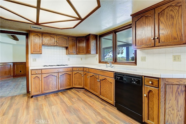 6735 Calais Ct, Riverside, CA 92506 - kitchen with dishwasher, brown cabinets, light wood finished floors, backsplash, and white gas cooktop