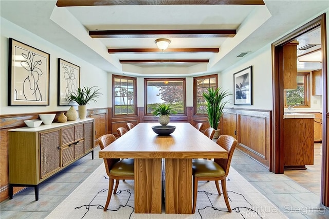 6735 Calais Ct, Riverside, CA 92506 - dining space featuring a wainscoted wall, plenty of natural light, a tray ceiling, beam ceiling, and light tile patterned flooring