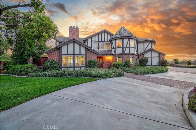 6735 Calais Ct, Riverside, CA 92506 - view of front of house featuring a chimney, brick siding, stucco siding, and a front yard
