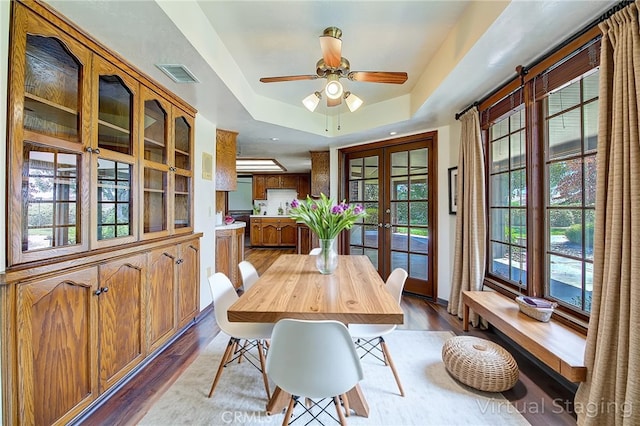 6735 Calais Ct, Riverside, CA 92506 - dining area featuring french doors, dark wood finished floors, a raised ceiling, and ceiling fan