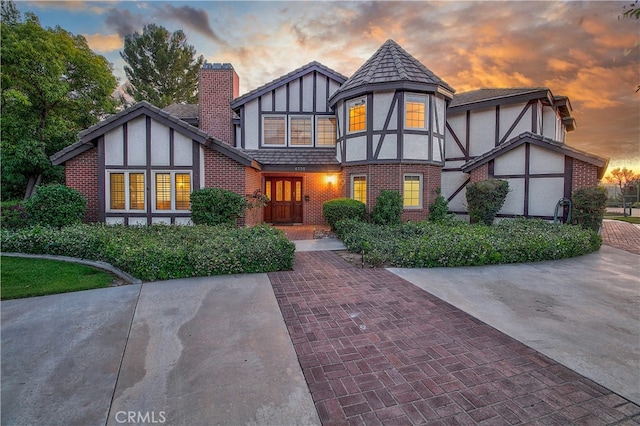 6735 Calais Ct, Riverside, CA 92506 - tudor-style house with brick siding, a chimney, and stucco siding