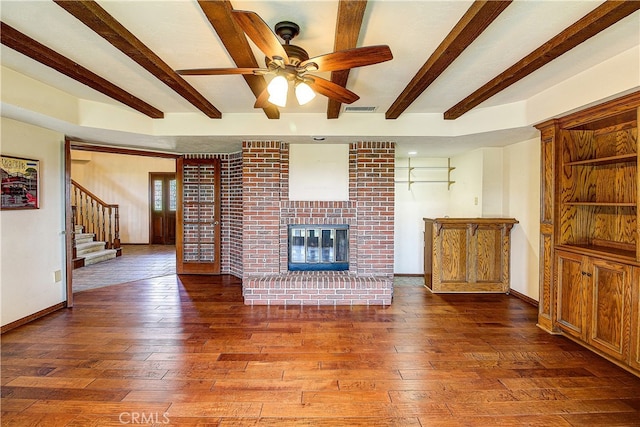 6735 Calais Ct, Riverside, CA 92506 - unfurnished living room featuring wood-type flooring, beam ceiling, ceiling fan, stairway, and a fireplace
