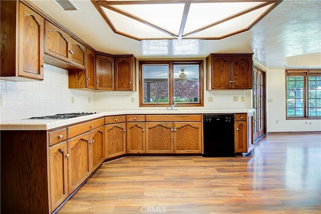 6735 Calais Ct, Riverside, CA 92506 - kitchen with black dishwasher, gas stovetop, light wood finished floors, and brown cabinetry