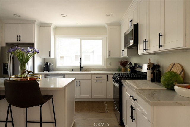 814 E Foothill Blvd, Monrovia, CA 91016 - kitchen with appliances with stainless steel finishes, a breakfast bar, white cabinetry, light countertops, and recessed lighting