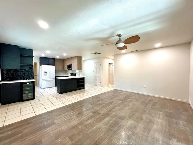 42915 Wisconsin Ave, Palm Desert, CA 92211 - kitchen featuring white refrigerator with ice dispenser, open shelves, beverage cooler, tasteful backsplash, and ceiling fan