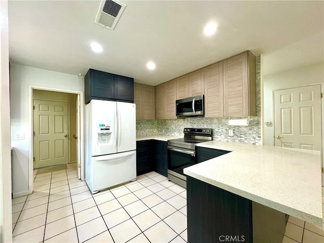 42915 Wisconsin Ave, Palm Desert, CA 92211 - kitchen featuring appliances with stainless steel finishes, a peninsula, light tile patterned floors, decorative backsplash, and recessed lighting