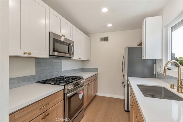 1640 235th St Unit D, Harbor City, CA 90710 - kitchen featuring appliances with stainless steel finishes, light wood-style flooring, backsplash, recessed lighting, and white cabinetry