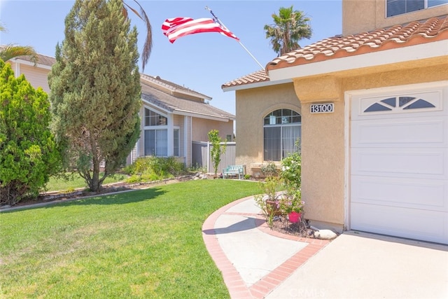 13100 Red Corral Dr, Corona, CA 92883 - view of exterior entry featuring stucco siding, a yard, a tiled roof, and a garage