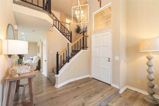 13100 Red Corral Dr, Corona, CA 92883 - foyer entrance featuring wood finished floors, stairway, a chandelier, and a towering ceiling