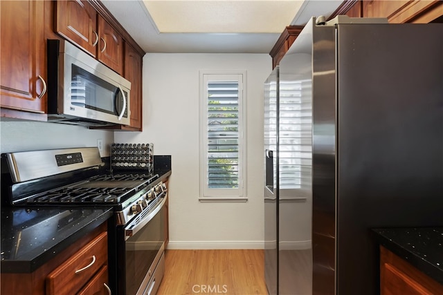 1103 Stone Pine Ln Unit C, Corona, CA 92879 - kitchen featuring appliances with stainless steel finishes, light wood finished floors, and dark stone counters
