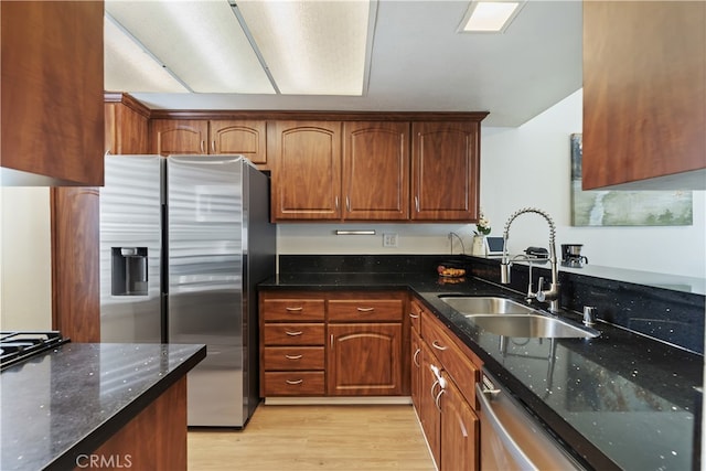 1103 Stone Pine Ln Unit C, Corona, CA 92879 - kitchen with stainless steel appliances, dark stone countertops, light wood finished floors, and brown cabinetry