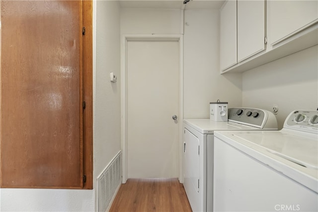 1103 Stone Pine Ln Unit C, Corona, CA 92879 - laundry area featuring washer and clothes dryer, cabinet space, and light wood-style flooring