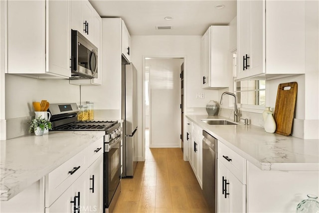 14519 Addison, Sherman Oaks, CA 91403 - kitchen featuring stainless steel appliances, light wood-type flooring, white cabinetry, and light stone counters