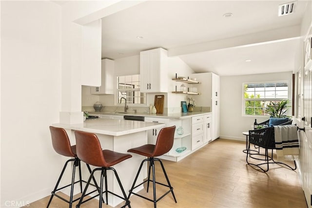 14519 Addison, Sherman Oaks, CA 91403 - kitchen featuring open shelves, a breakfast bar area, white cabinetry, light wood-type flooring, and a peninsula