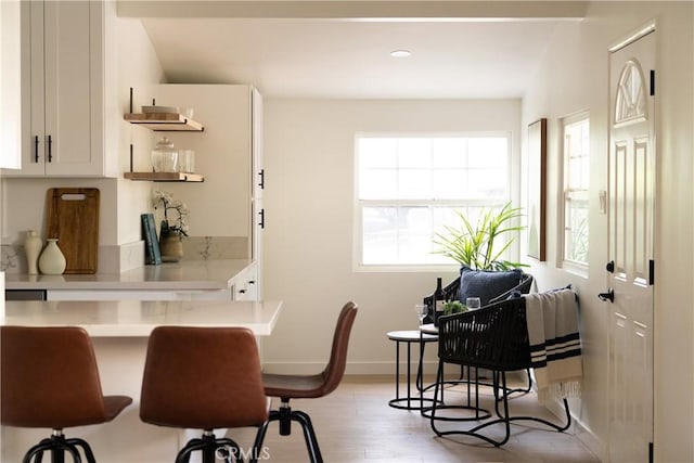 14519 Addison, Sherman Oaks, CA 91403 - kitchen featuring light countertops, light wood-type flooring, white cabinets, a breakfast bar, and recessed lighting
