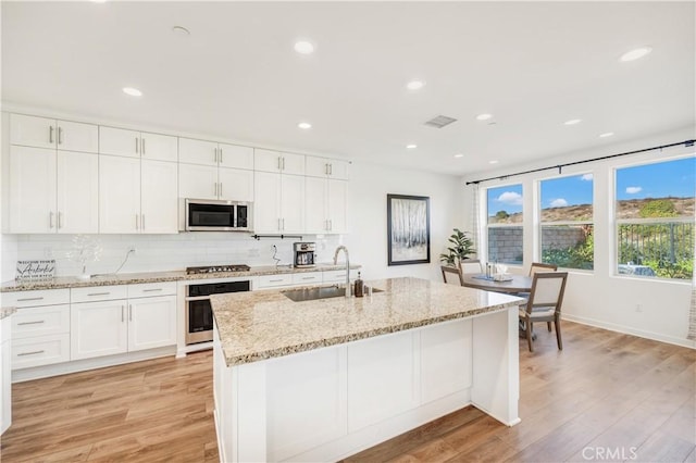 97 Eclipse, Lake Forest, CA 92630 - kitchen featuring stainless steel appliances, white cabinetry, light wood-style flooring, light stone counters, and recessed lighting